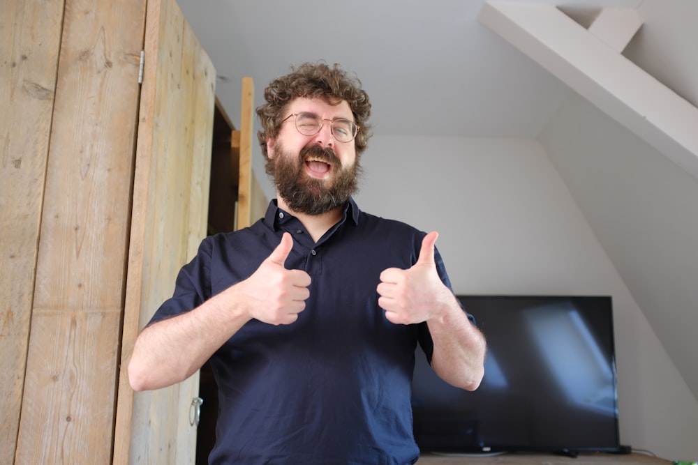 a man with a beard giving a thumbs up