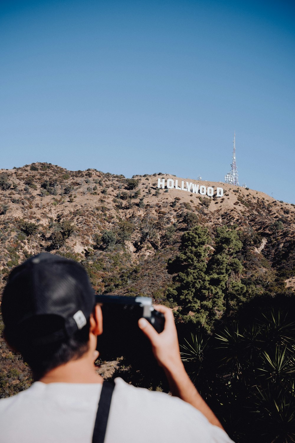 um homem tirando uma foto do sinal de hollywood