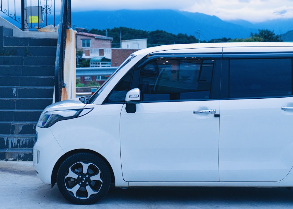 a white minivan parked in front of a building