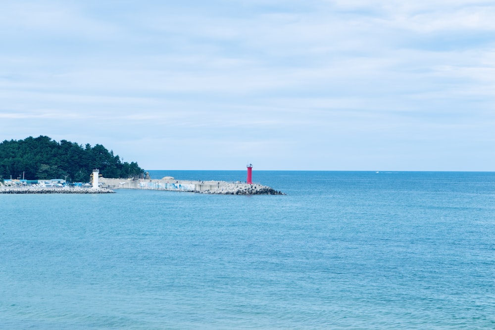 a lighthouse on a small island in the middle of the ocean