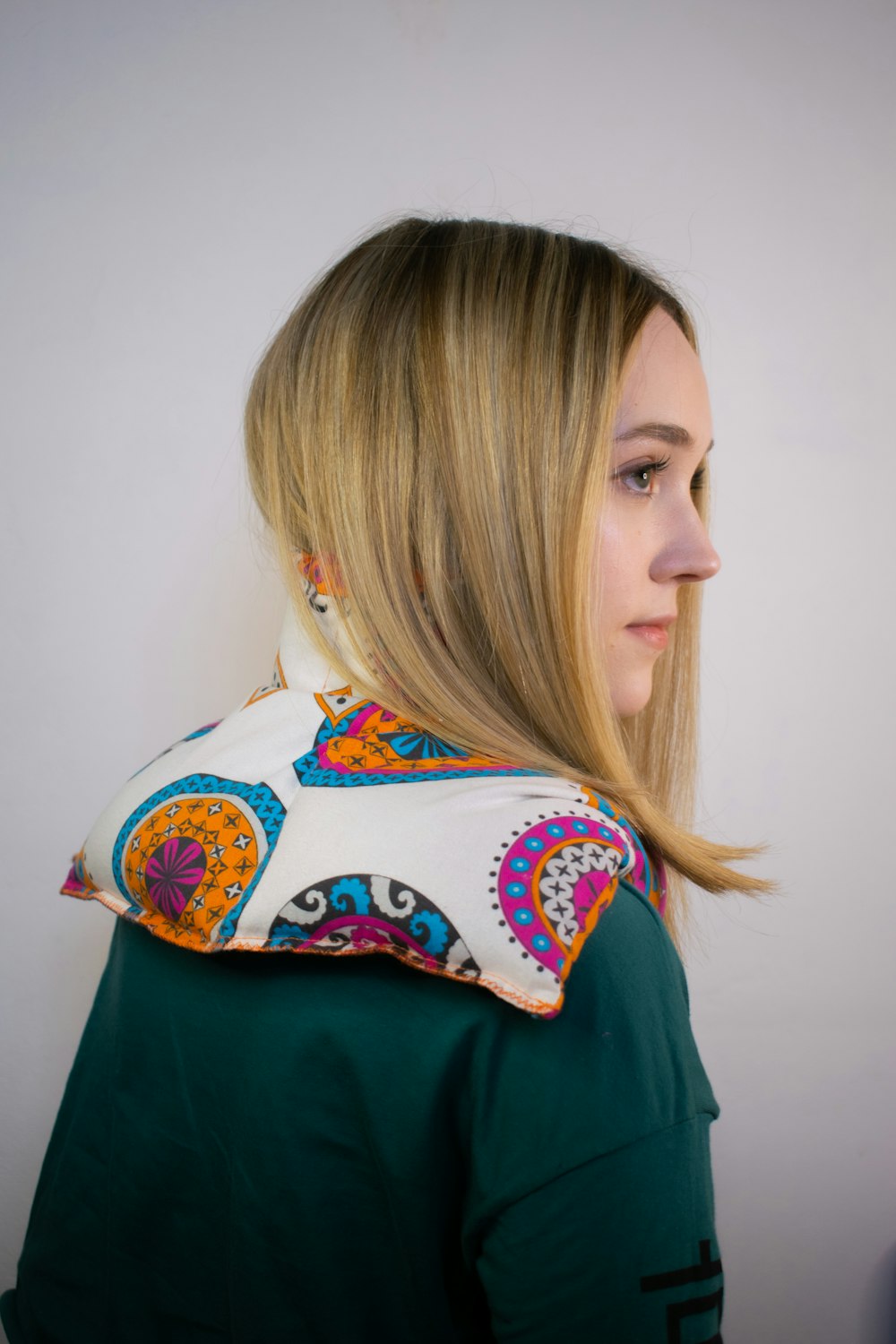 a woman with long blonde hair wearing a scarf