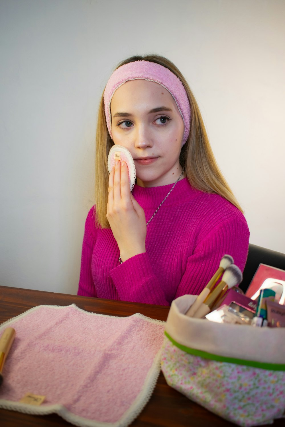 a girl in a pink sweater is holding a brush