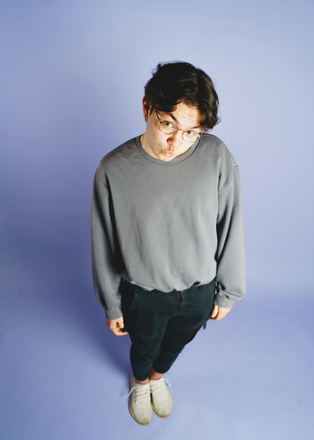 a young man wearing glasses and a sweater