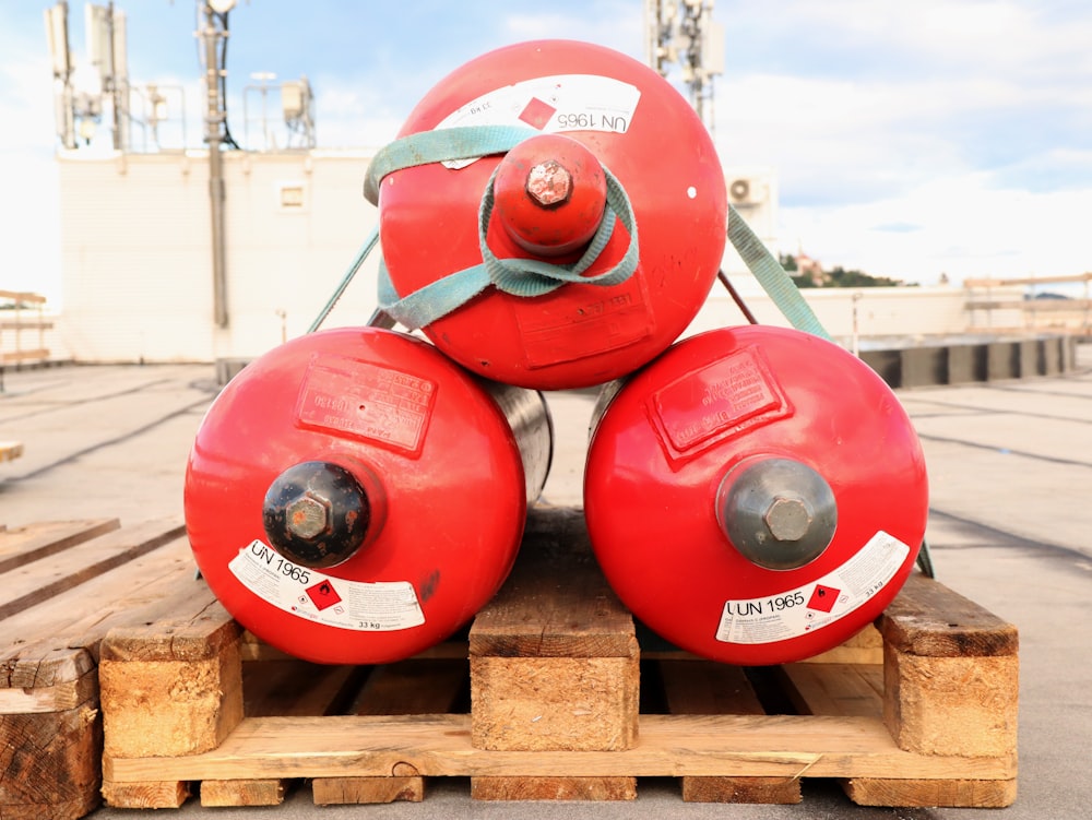 a couple of red fire hydrants sitting on top of a wooden pallet