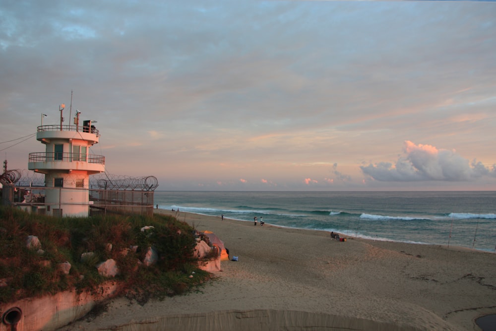 a lifeguard tower on a beach at sunset