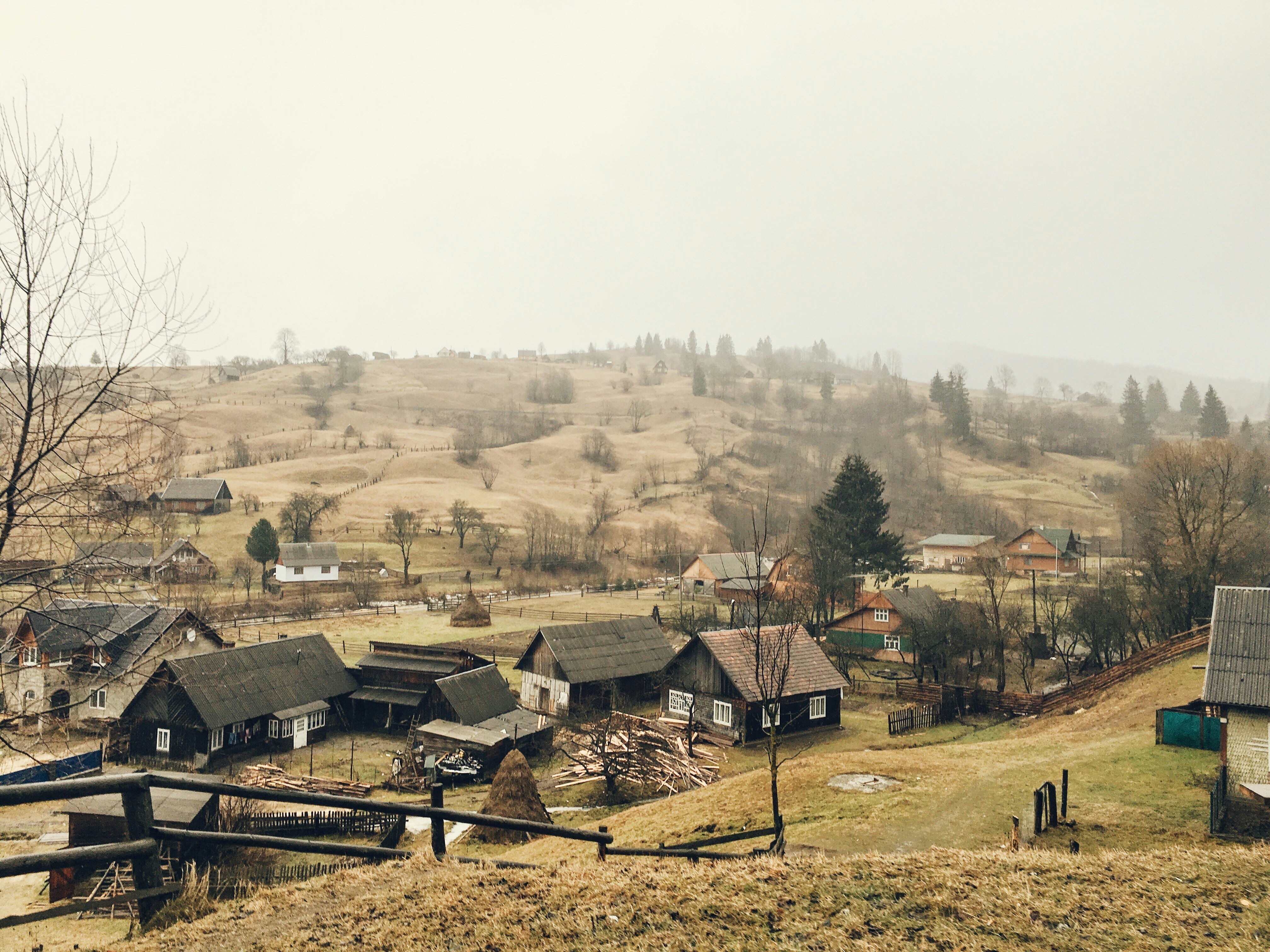 Rural village nestled in rolling, misty hillsides.