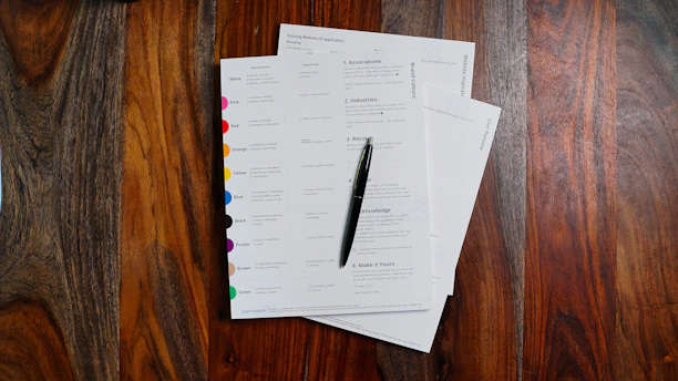 a stack of papers sitting on top of a wooden table