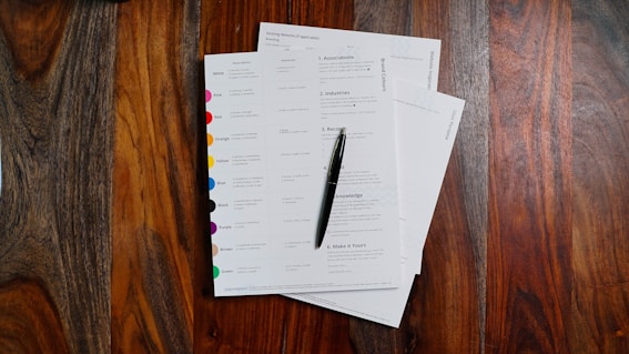a stack of papers sitting on top of a wooden table