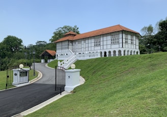 a large white building with a red roof on top of a hill