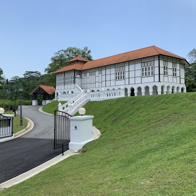 a large white building with a red roof on top of a hill