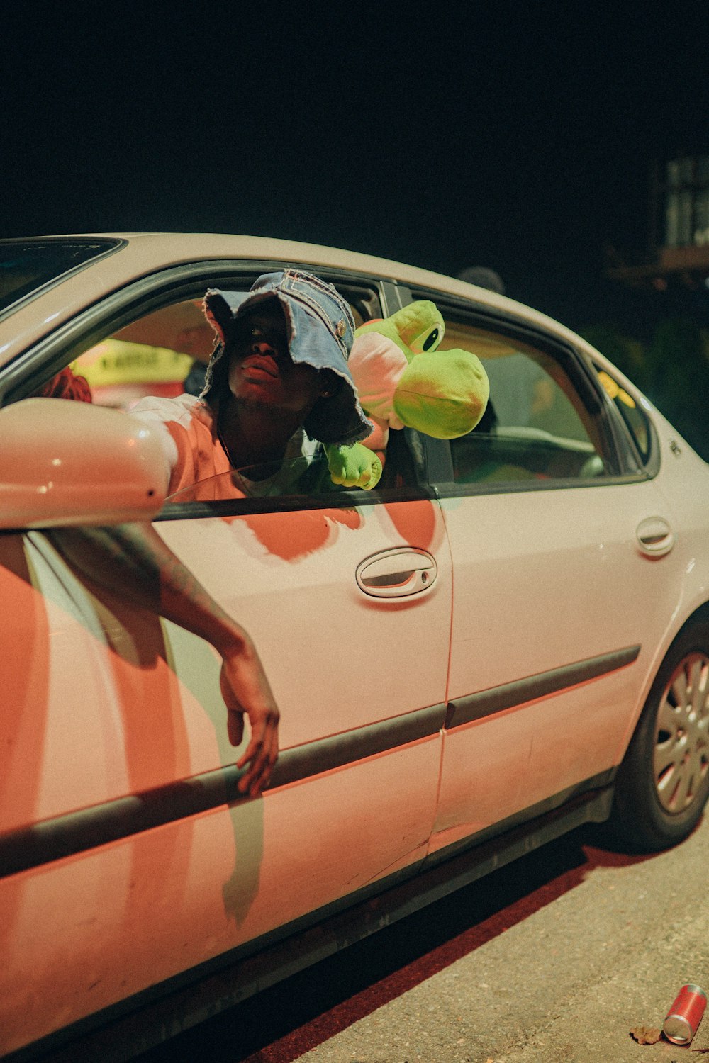 a man sitting in a car with stuffed animals in the window