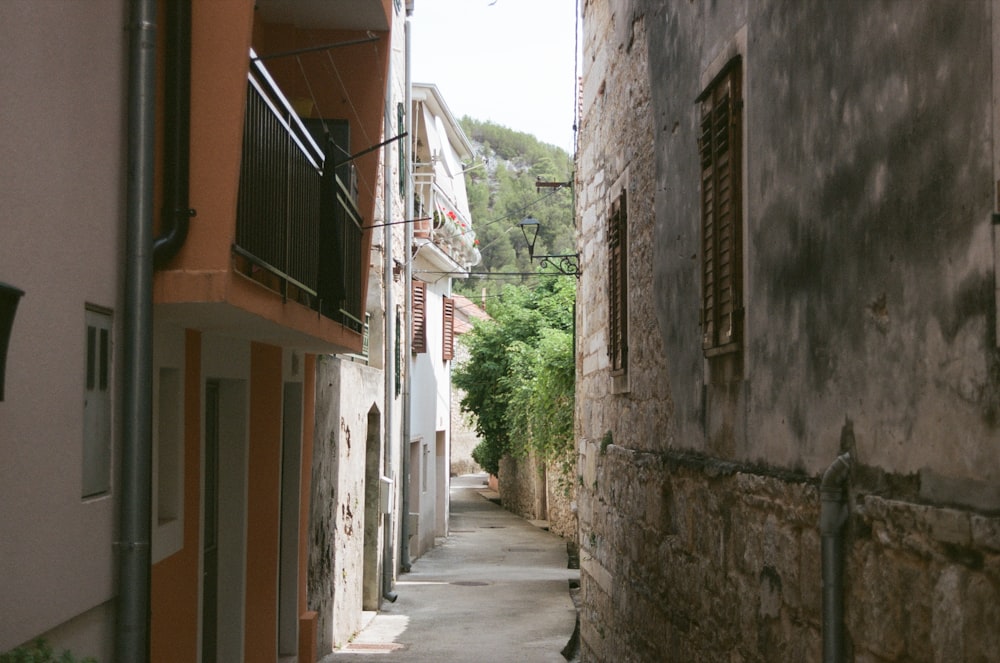 a narrow alley way with buildings and trees