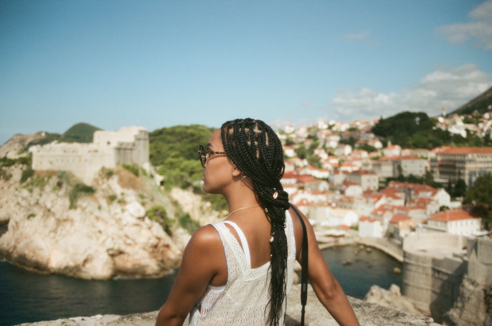 a woman with braids looking out over a city