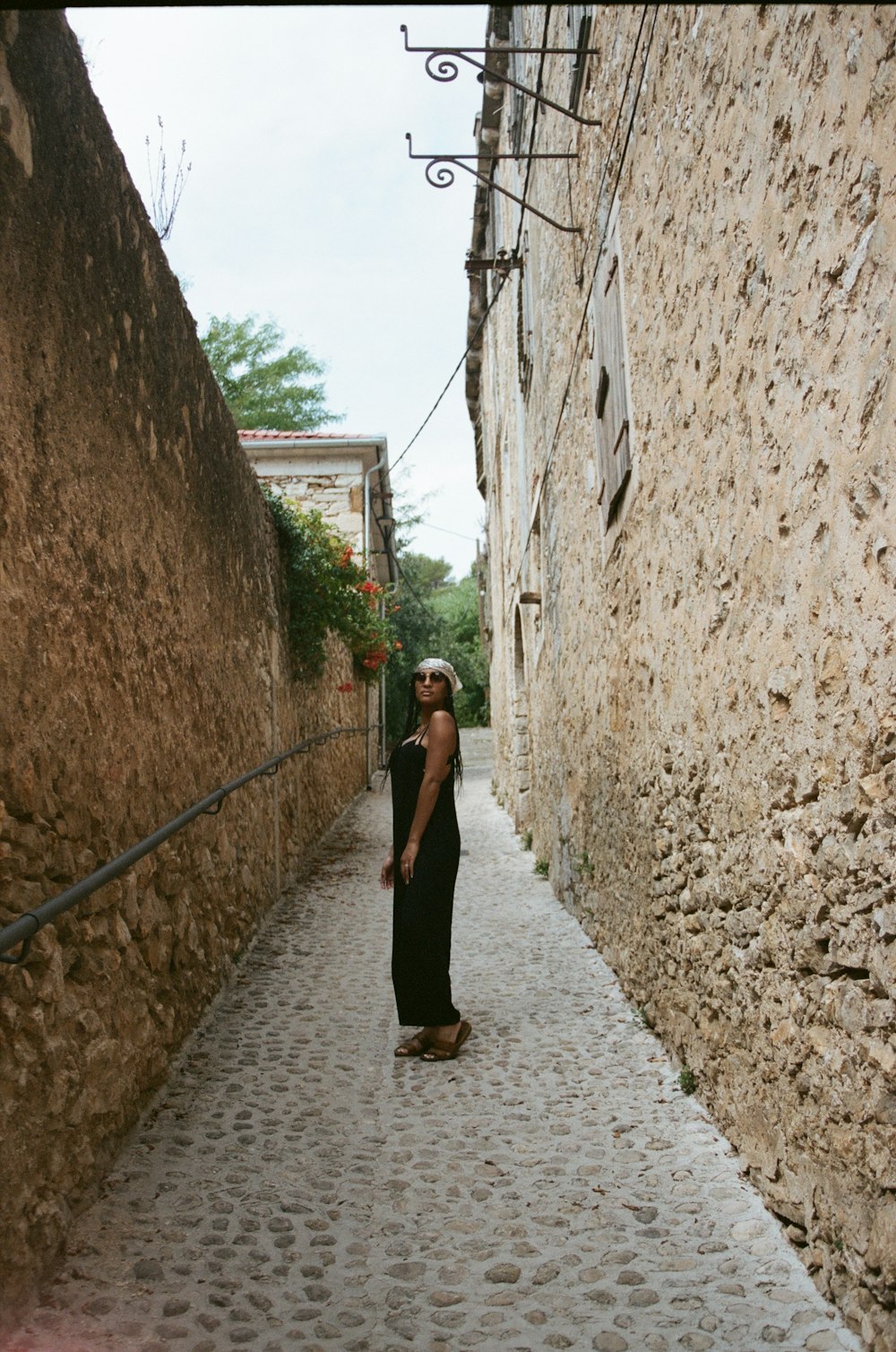 a woman walking down a narrow alley way