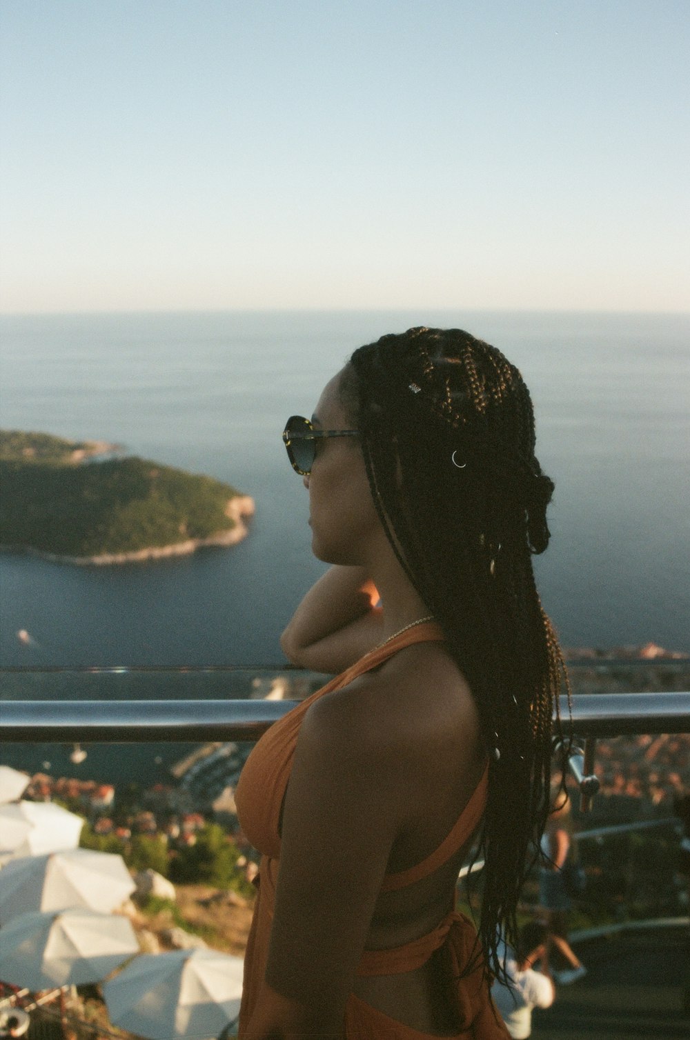 a woman standing on top of a hill overlooking a body of water