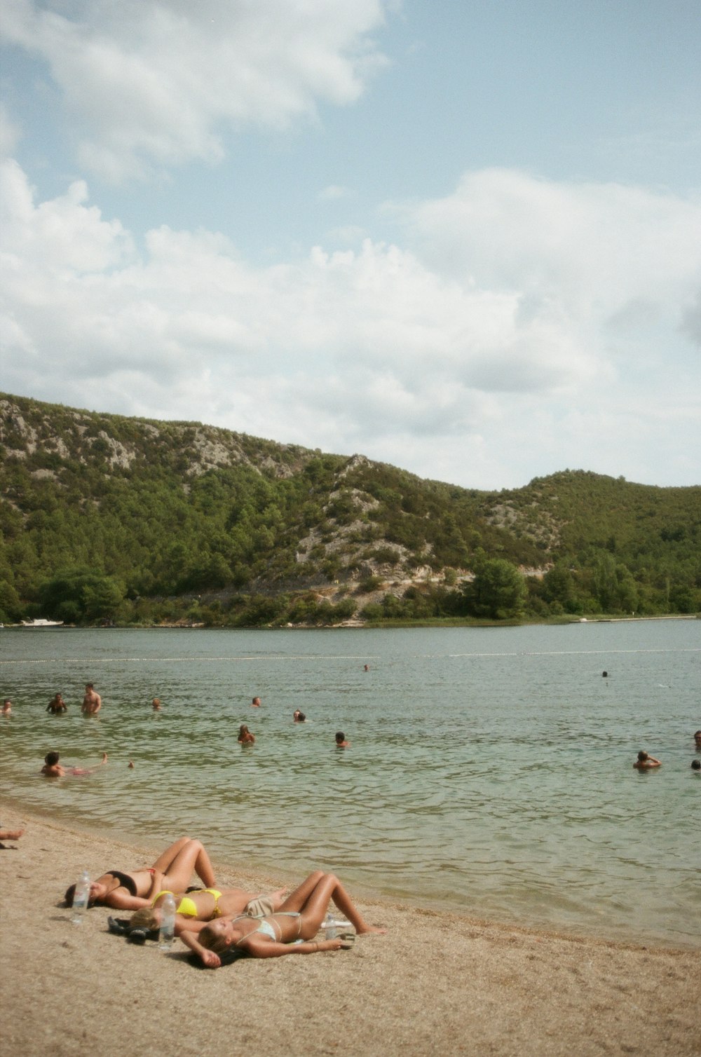 a group of people laying on top of a sandy beach