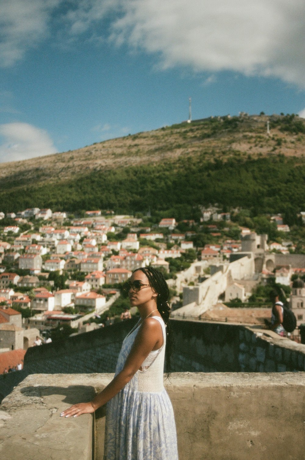a woman in a white dress standing on a ledge