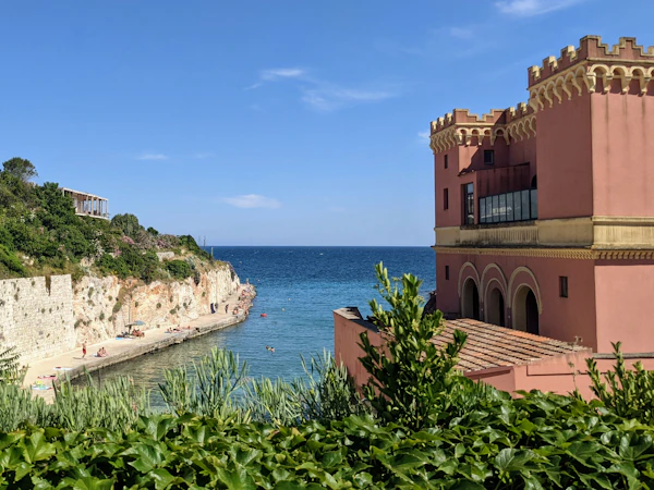A pink building on a cliff above the sea in Polignano a Mare, Puglia — one of 15 destinations worth traveling to in September 2026