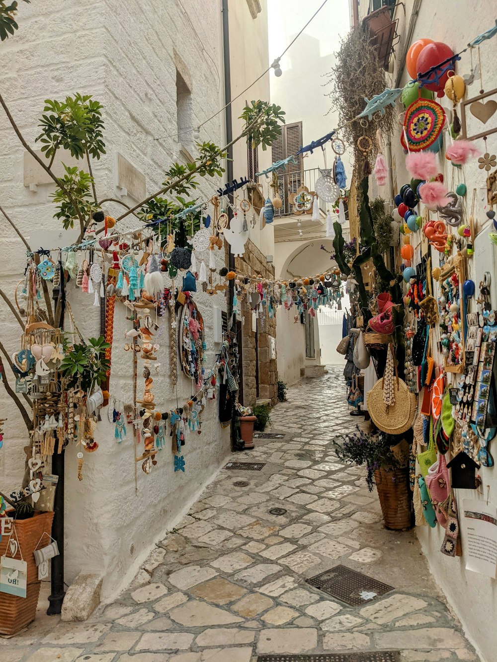 a narrow alley way with a bunch of items hanging on the wall