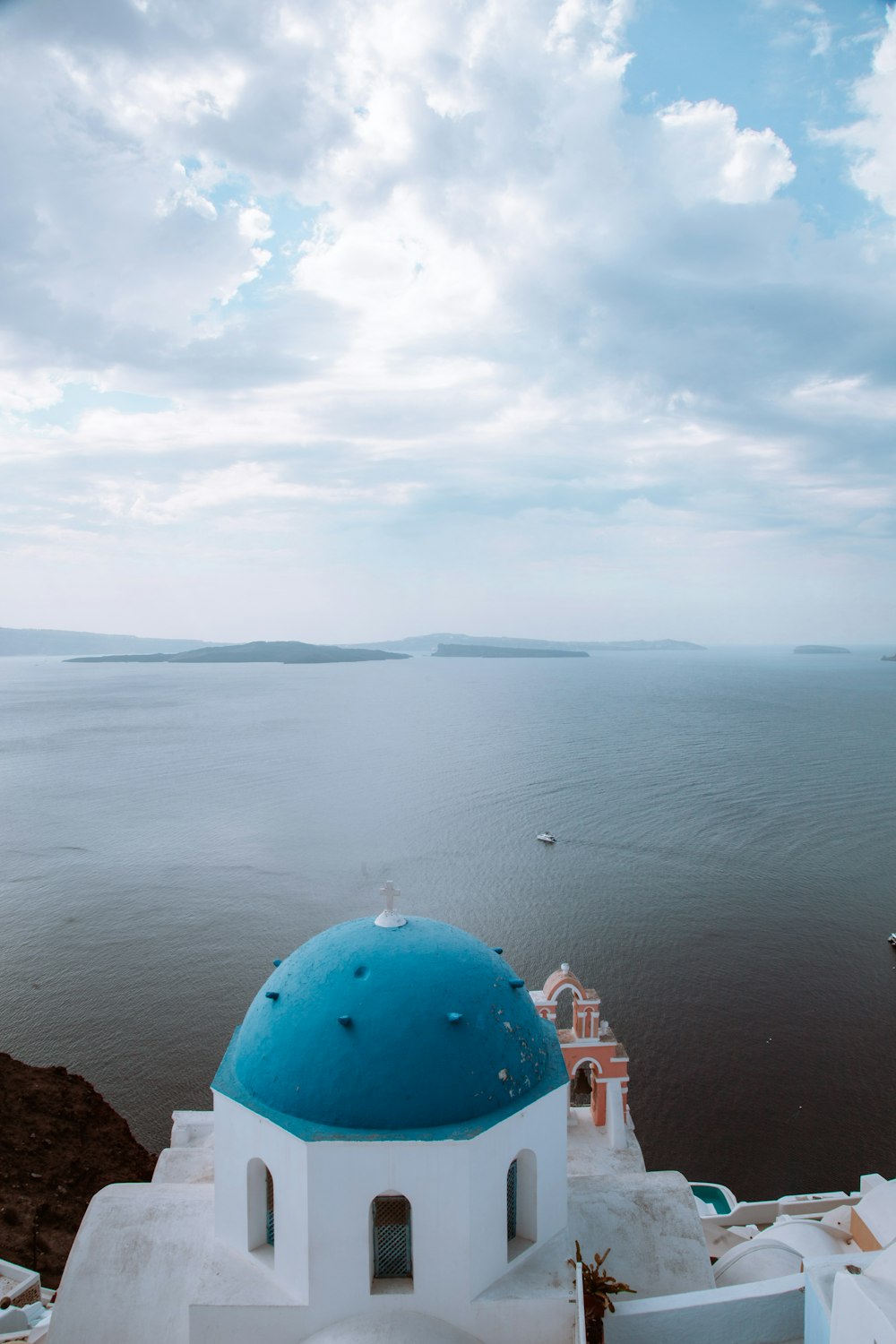 a blue dome on top of a building next to a body of water