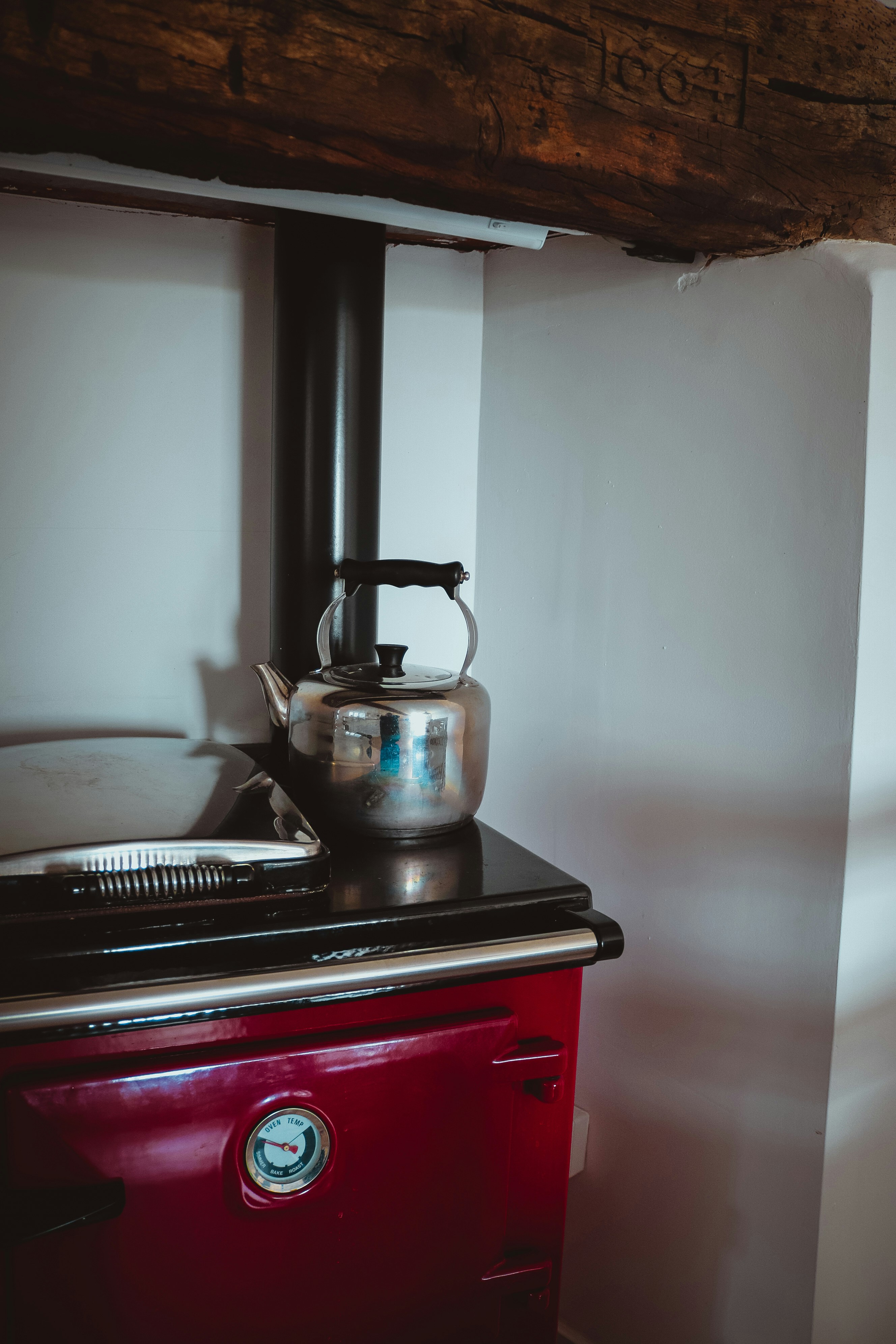 a red stove with a tea kettle on top of it