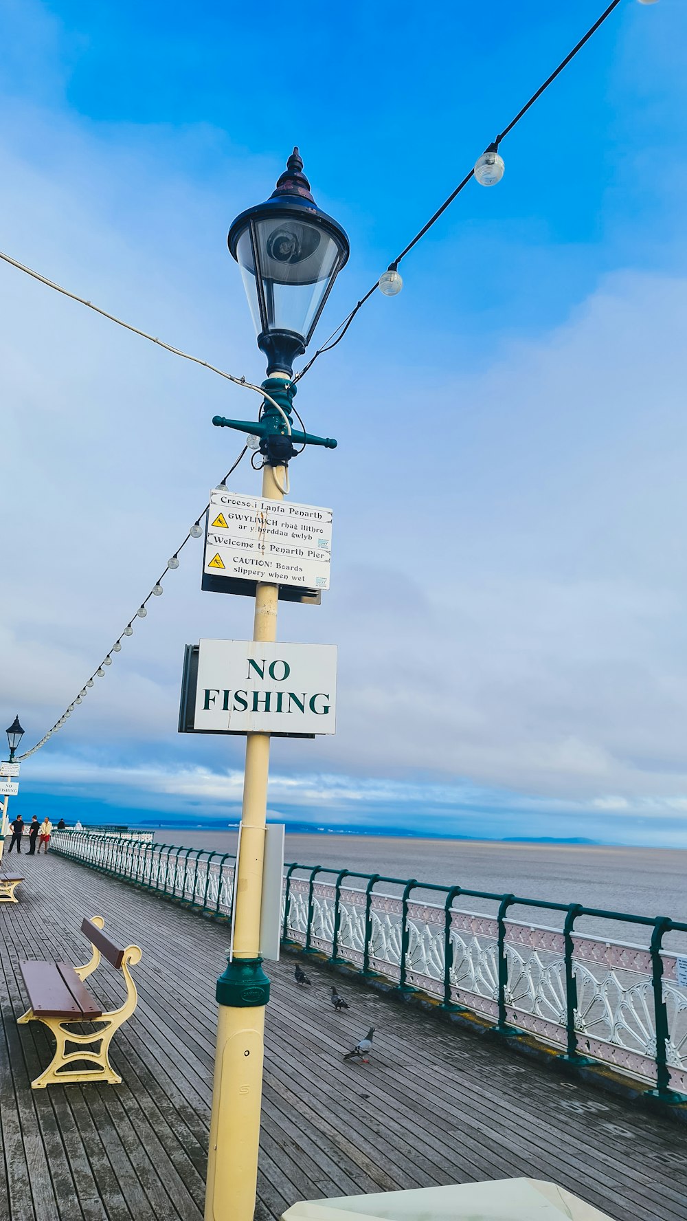 a street light sitting on the side of a pier