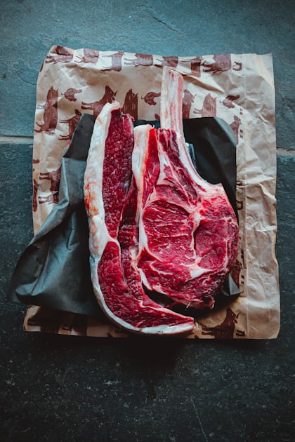 A slab of raw meat on a cutting board with vegetables and a bowl of sauce  photo – Free Steak Image on Unsplash