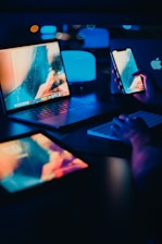 a person sitting at a desk with two laptops