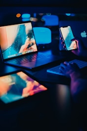 a person sitting at a desk with two laptops