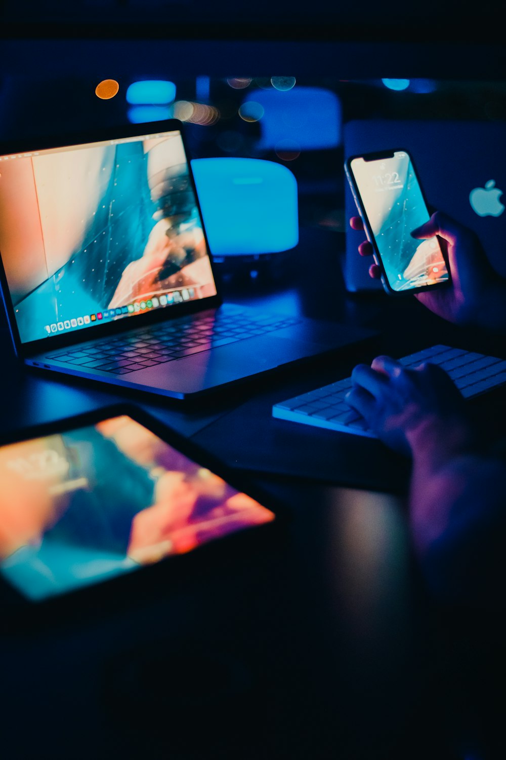 a person sitting at a desk with two laptops