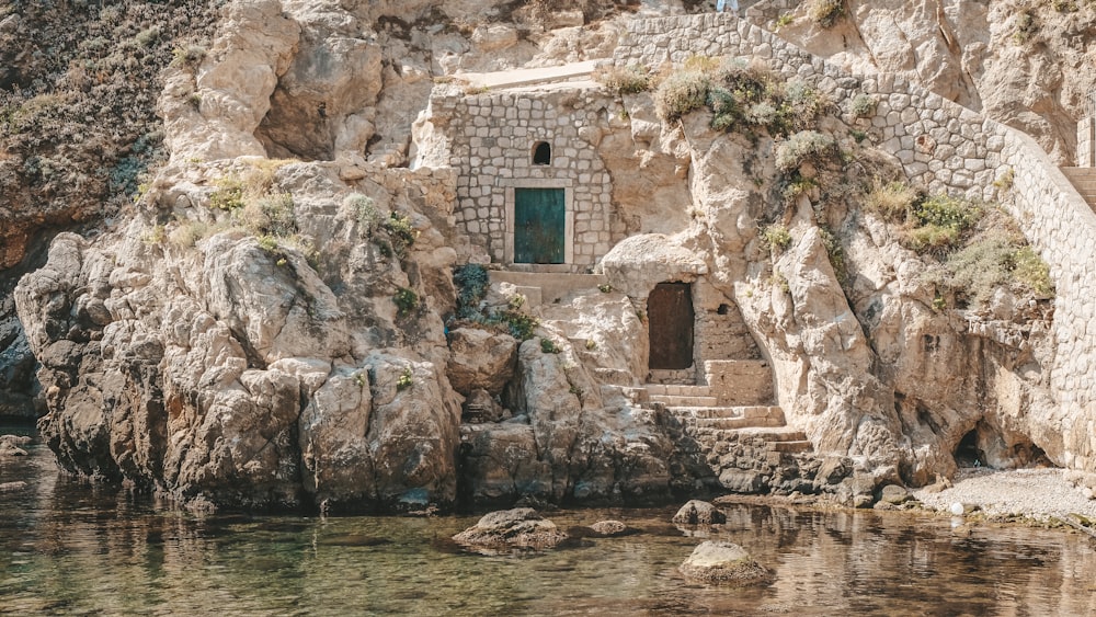 a building built into the side of a cliff next to a body of water