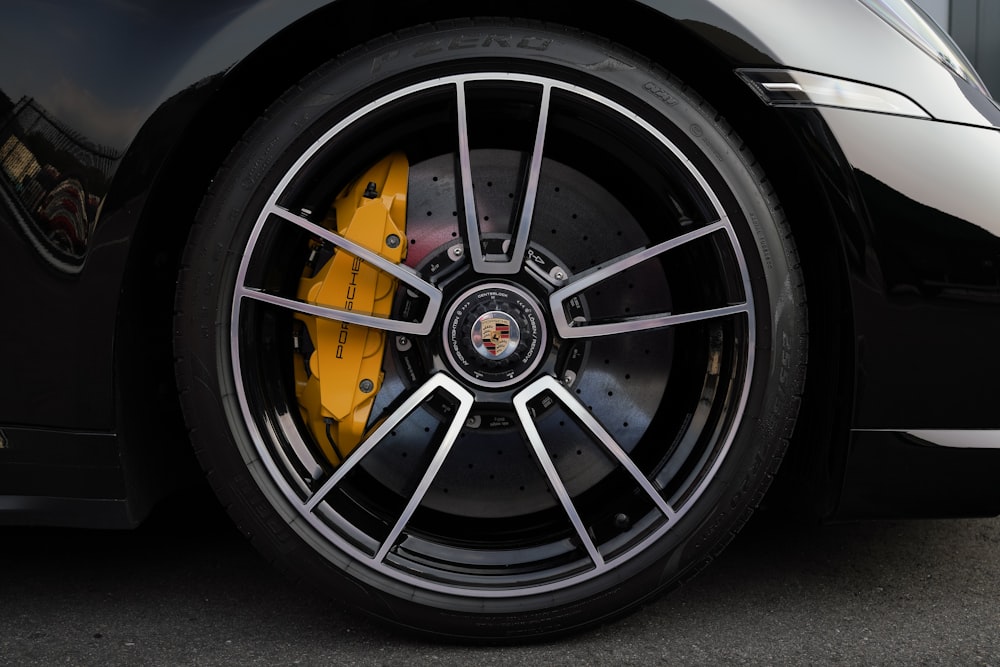 a black sports car with yellow brake pads
