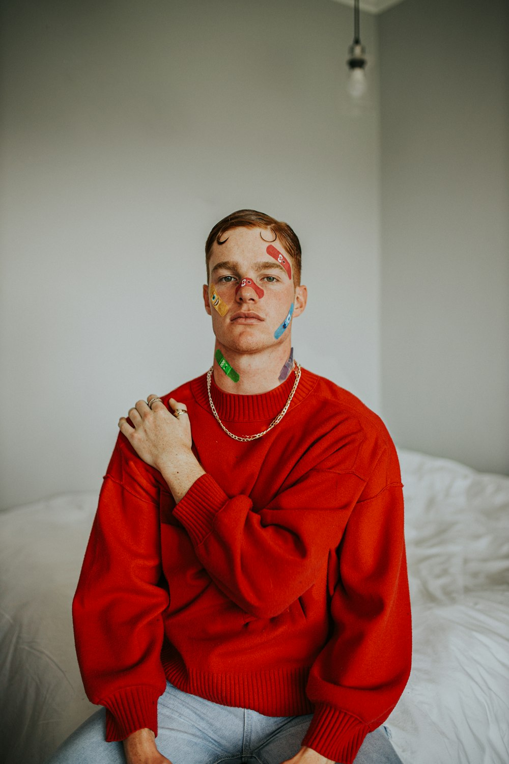 a man with face paint sitting on a bed
