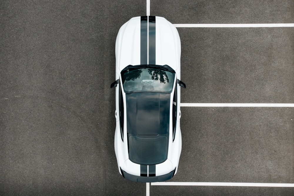an overhead view of a white car parked in a parking lot