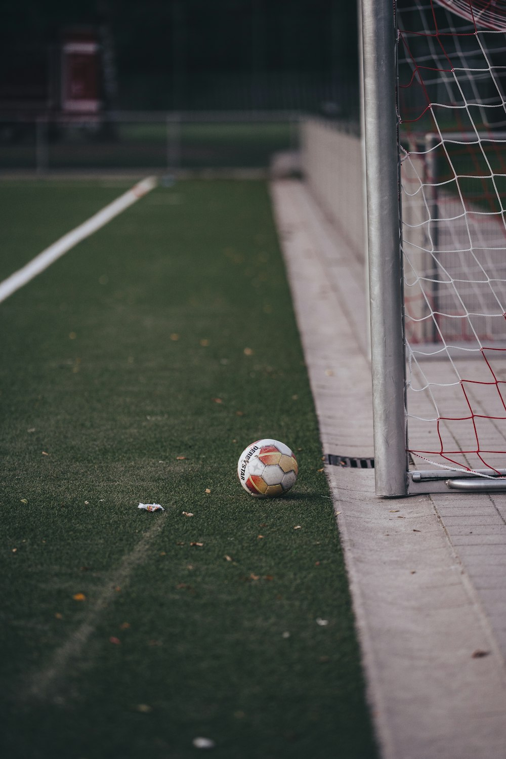 a soccer ball sitting on the ground next to a goal