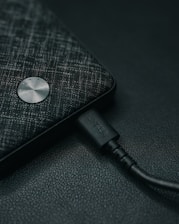 a close up of a cell phone with a charger plugged in