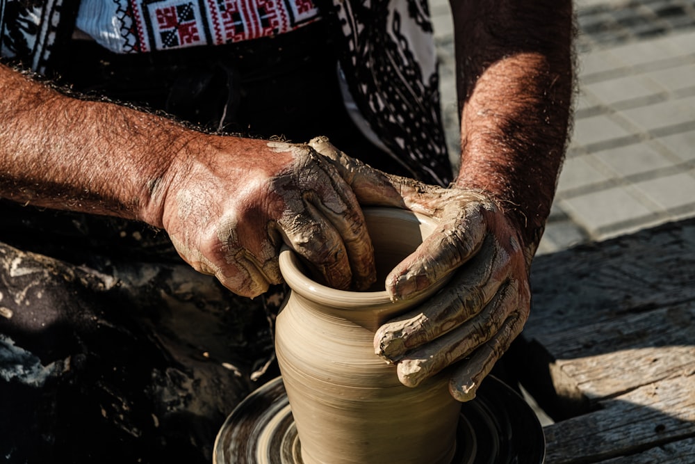 男が粘土で花瓶を作っている