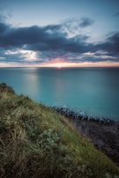 A stunning view of a coastal property with a sunset in the background.