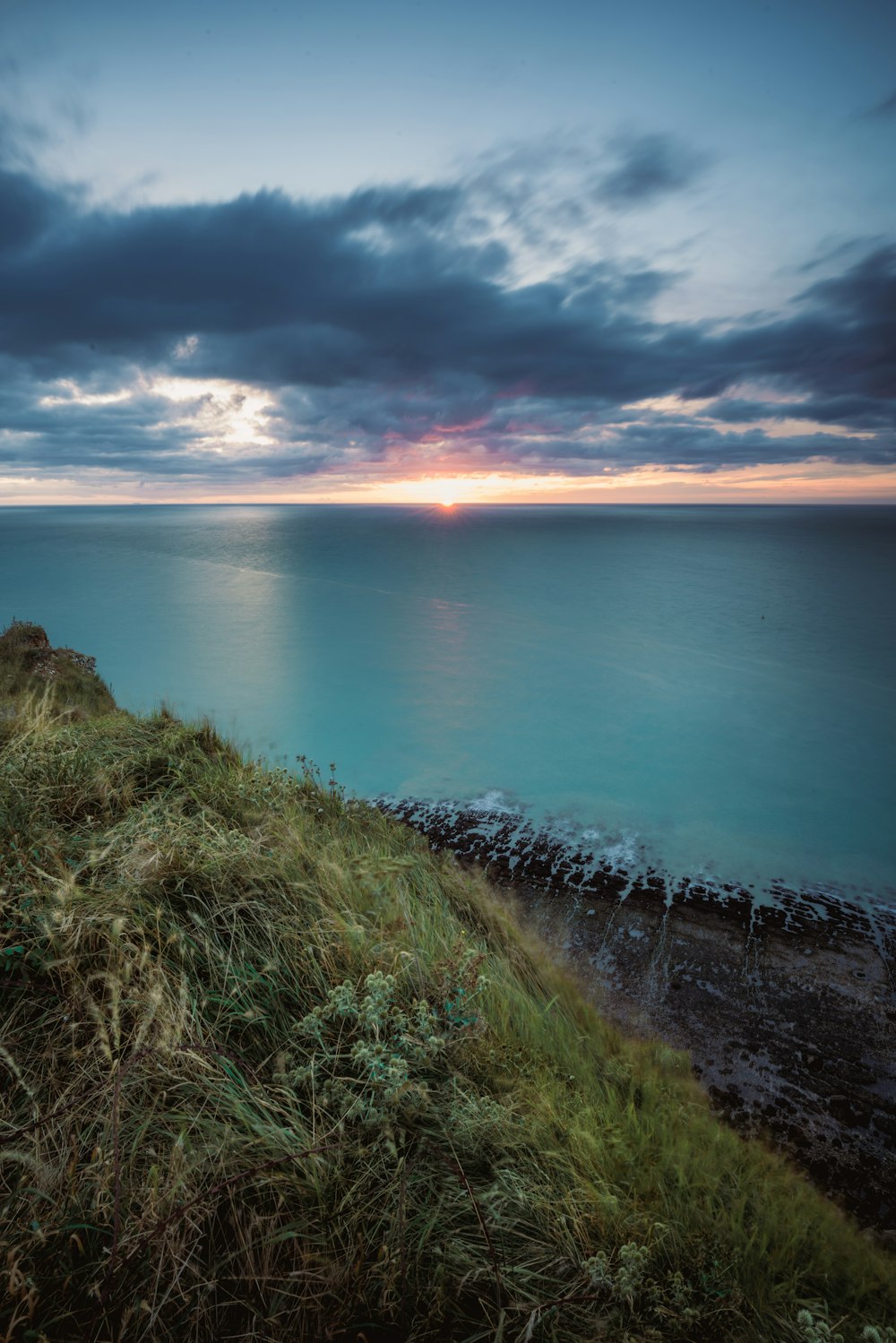 Le soleil se couche sur l’océan par temps nuageux