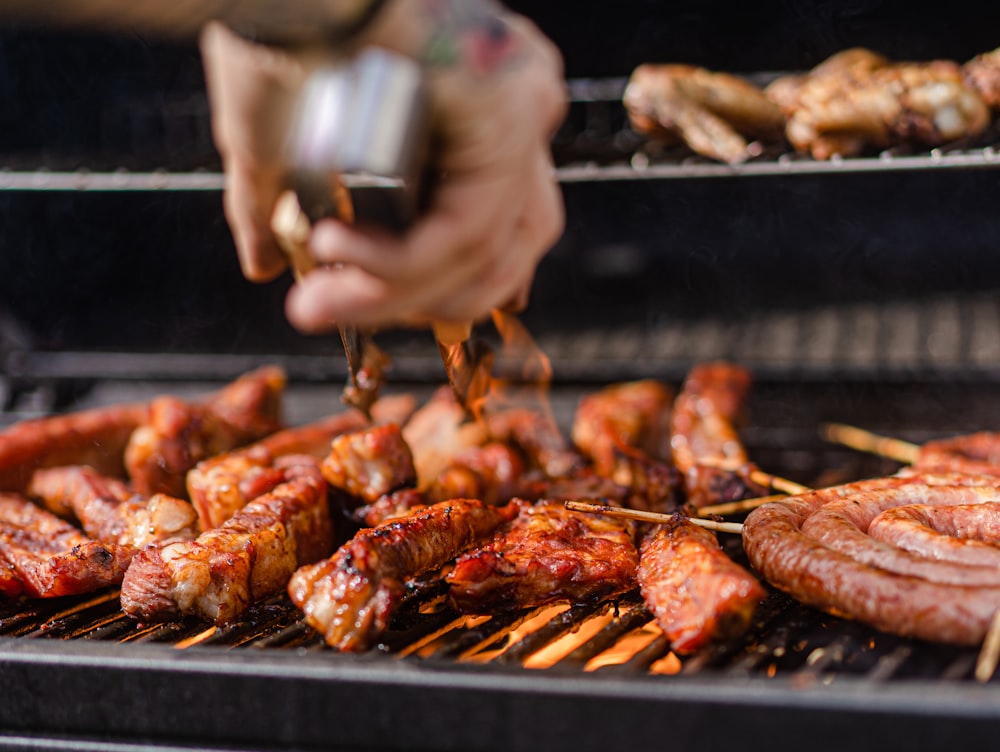 a person is cooking meat on a grill