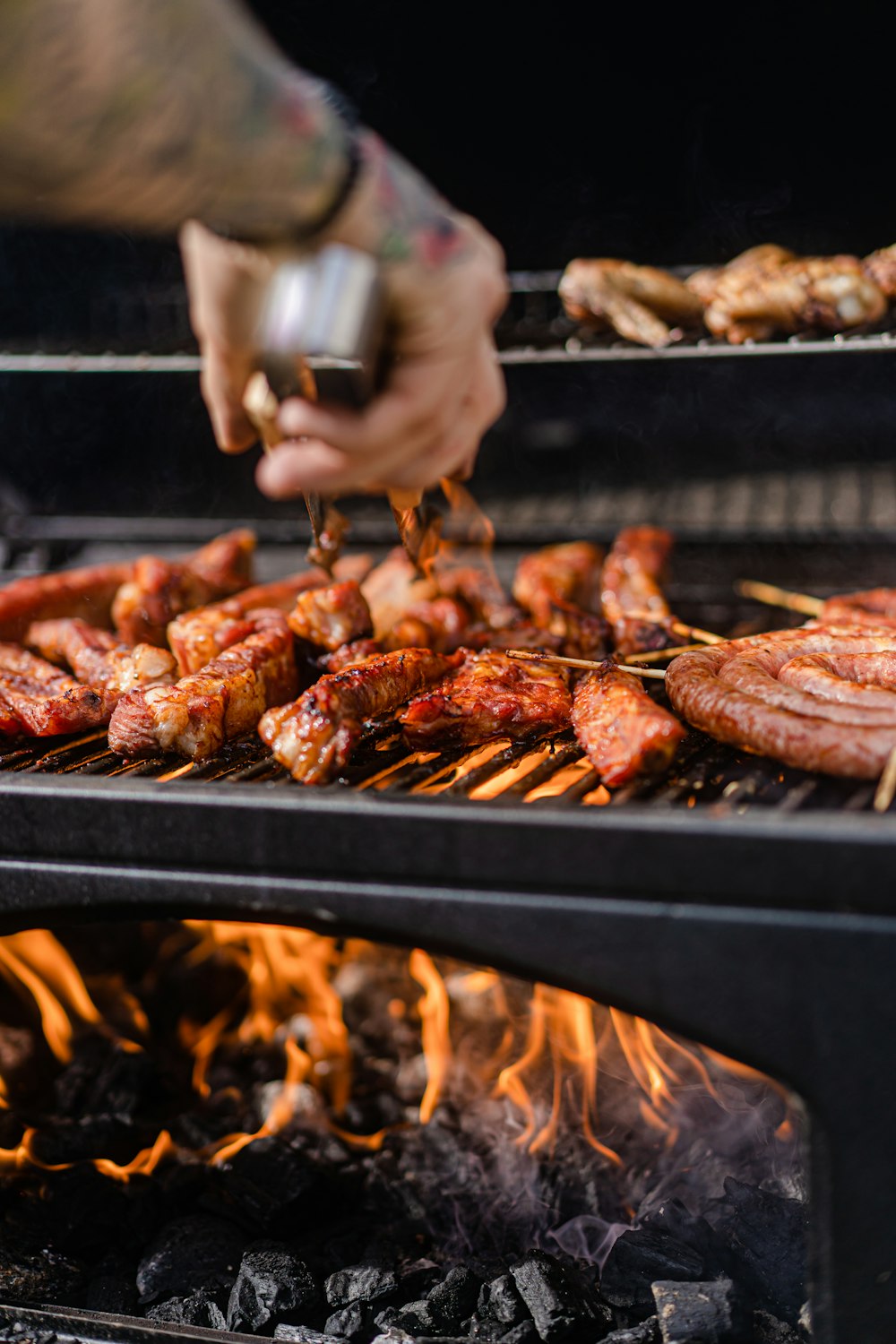 Eine Person kocht Fleisch auf einem Grill