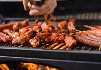 a person is cooking meat on a grill