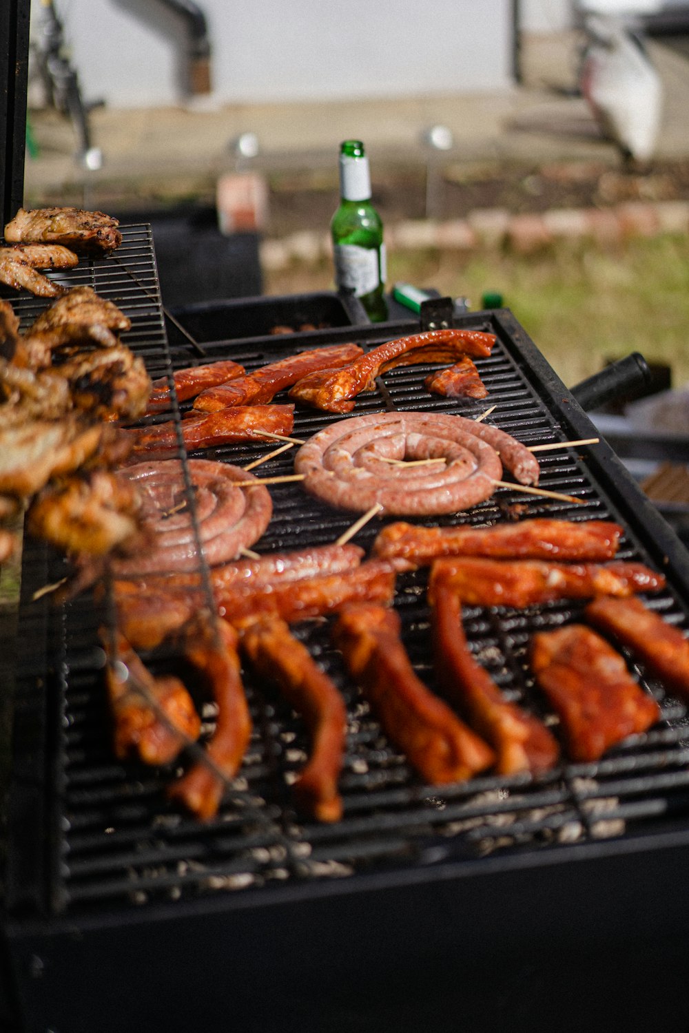a bbq grill with sausages and hot dogs on it