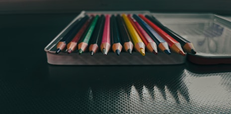 a row of colored pencils sitting on top of a table