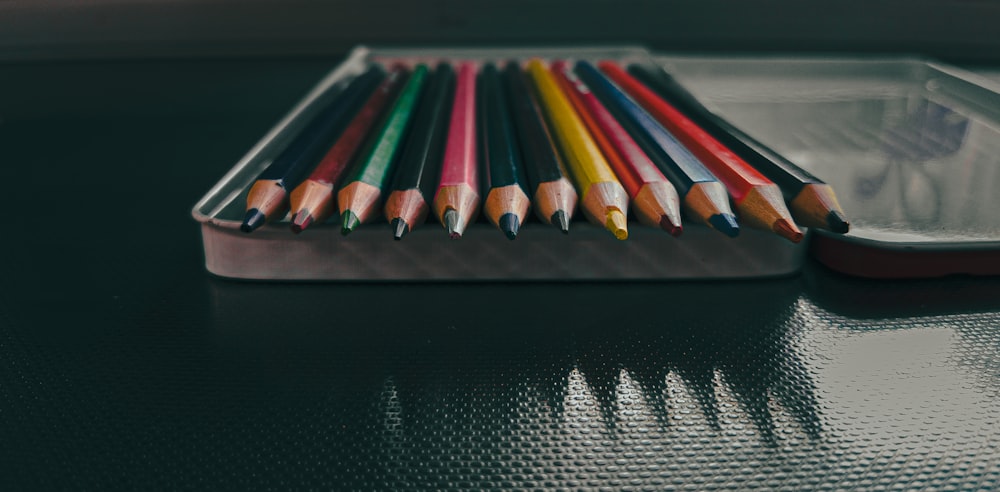 a row of colored pencils sitting on top of a table