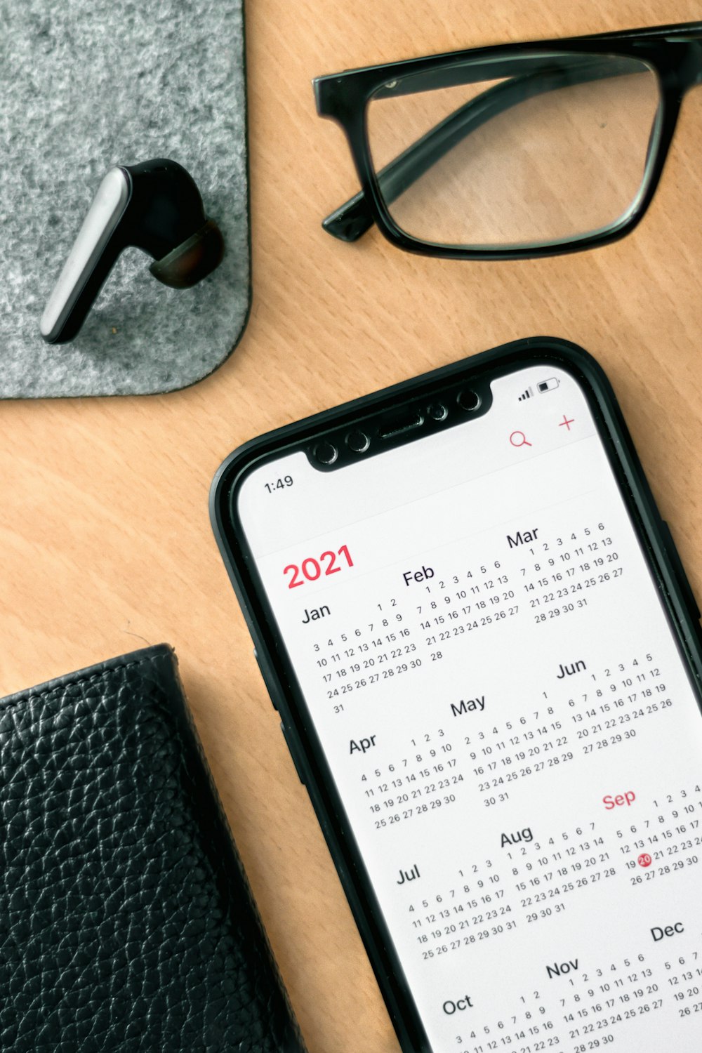 a phone with a calendar on it next to a pair of glasses