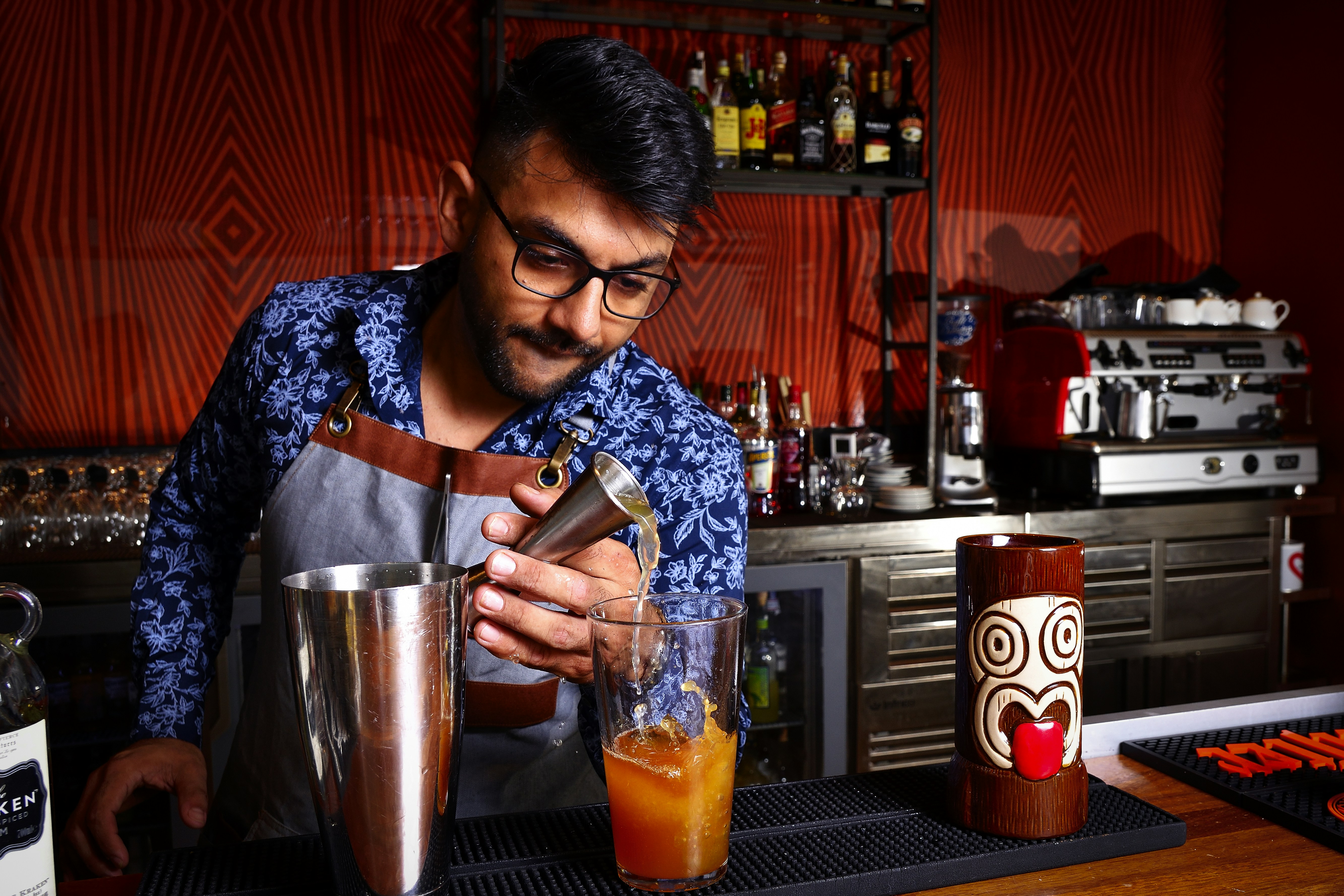 A bartender pours a tropical drink