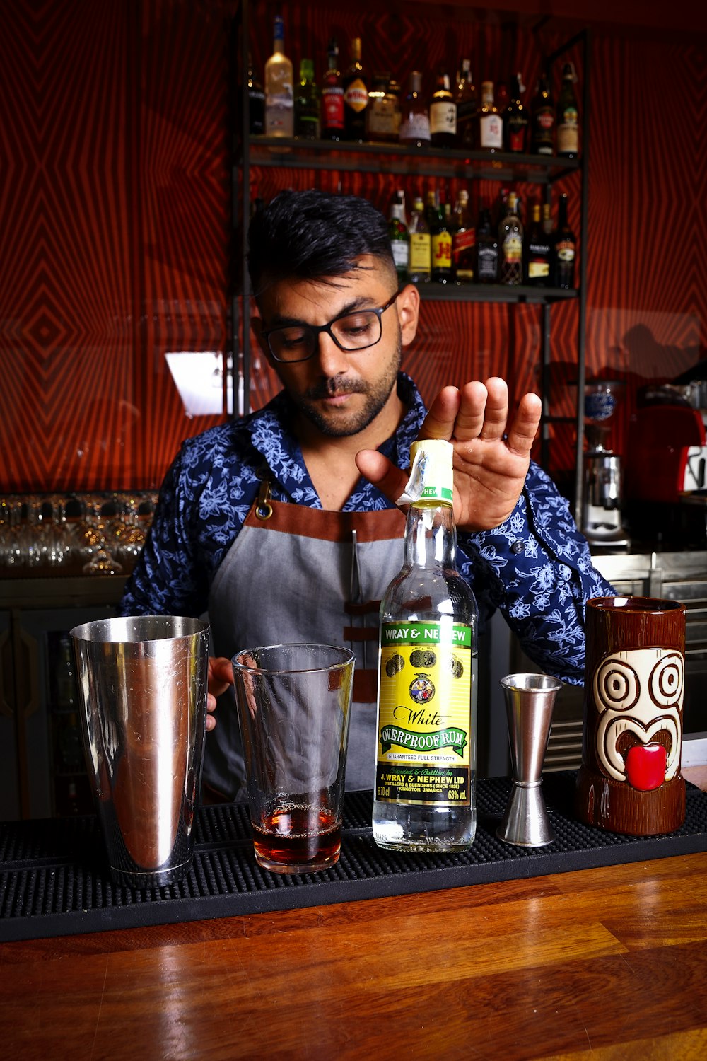 a man making a drink behind a bar