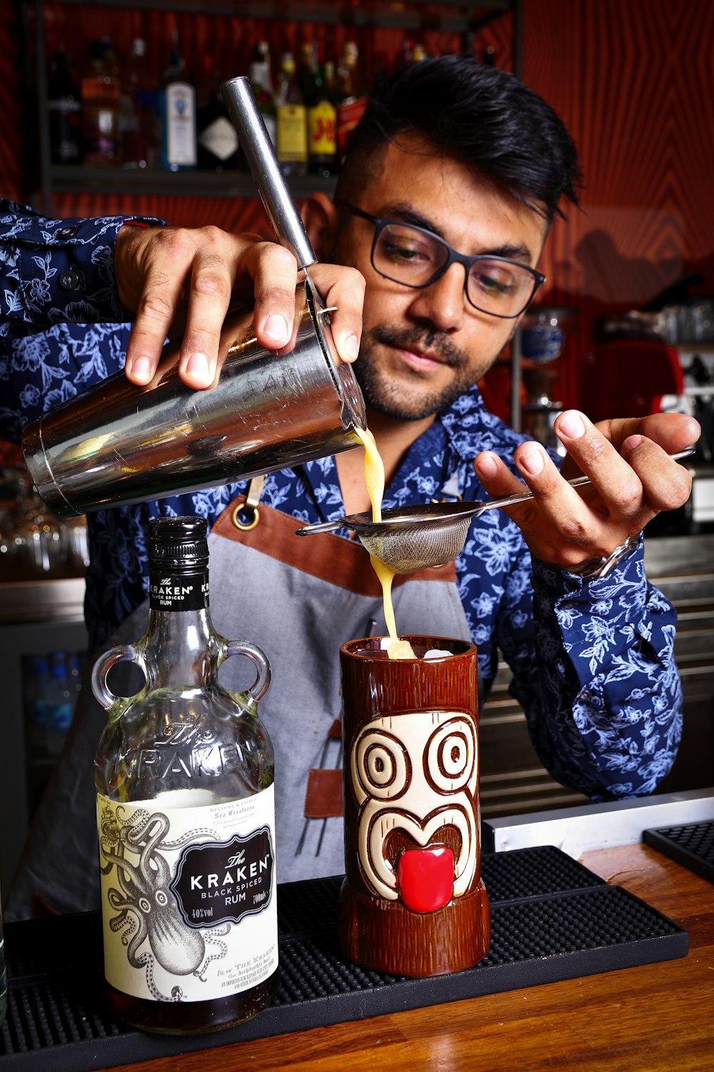 a man pouring a drink into a glass