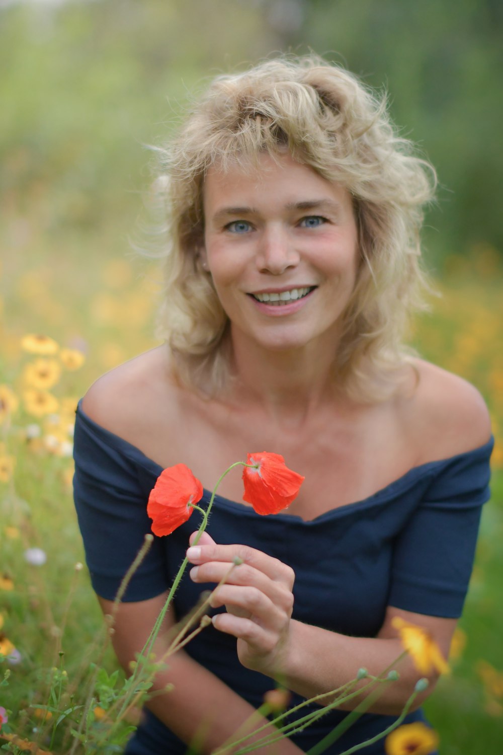 a woman sitting in a field of flowers